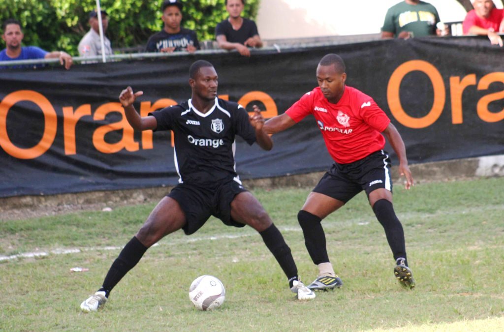 ean Wildy Louis de Moca protege el esférico de un jugador de Bauger FC